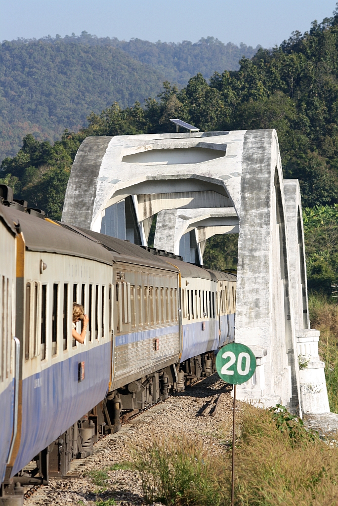 Der EXP 52 von Chiang Mai nach Bangkok fährt circa 2km nach dem Bf. Tha Chomphu über die einzige Eisenbahn-Spannbetonbrücke der thailändischen Staatsbahn. Das Signal im Vordergrund kündigt eine Langsamfahrstelle mit 20km/h an.