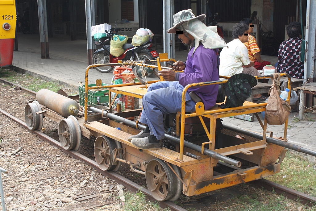 Der Fahrer des Kleinwagen der Type รบ.6 (รบ.=RB.) vertreibt sich bis zur Abfahrt des 1221 die Zeit; Ban Laem Station am 07.Dezember 2010.