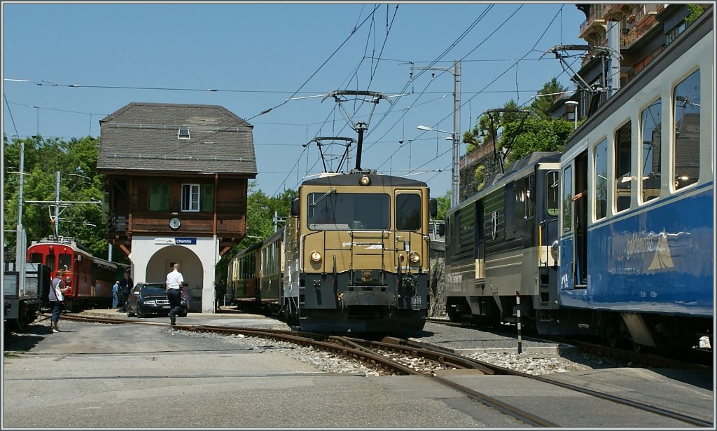 Der GoldenPass Classic mit der GDe 4/4 6005 auf der Fahrt nach Montreux wartet in Chamby auf die Kreuzung mit dem nun einfahrenden Regionalzug 2224 mit der GDe 4/4 6004  Interlaken  unterwegs nach Zweisimmen. 

27. Mai 2012