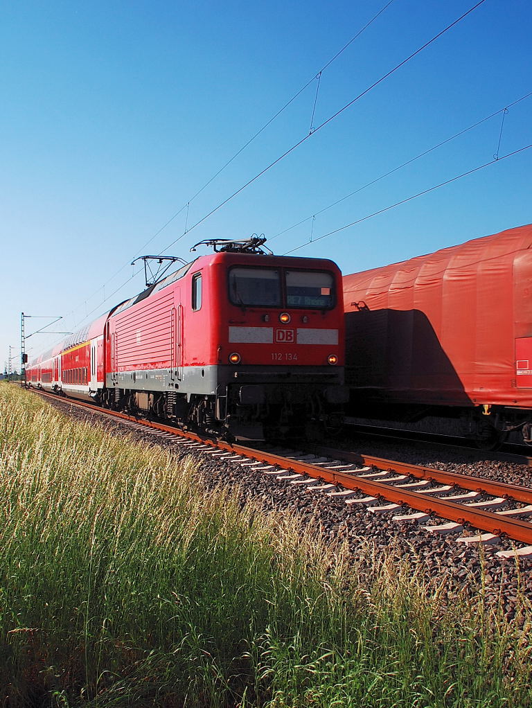 Der Gterzug auf dem Richtungsgleis nach Neuss, ist der von der 189 085-4 gezogene und der von der 112 134 gezogene RE7 ist im Richtung Kln unterwegs auf der Kbs 495 bei Allerheiligen am 26.5.2012