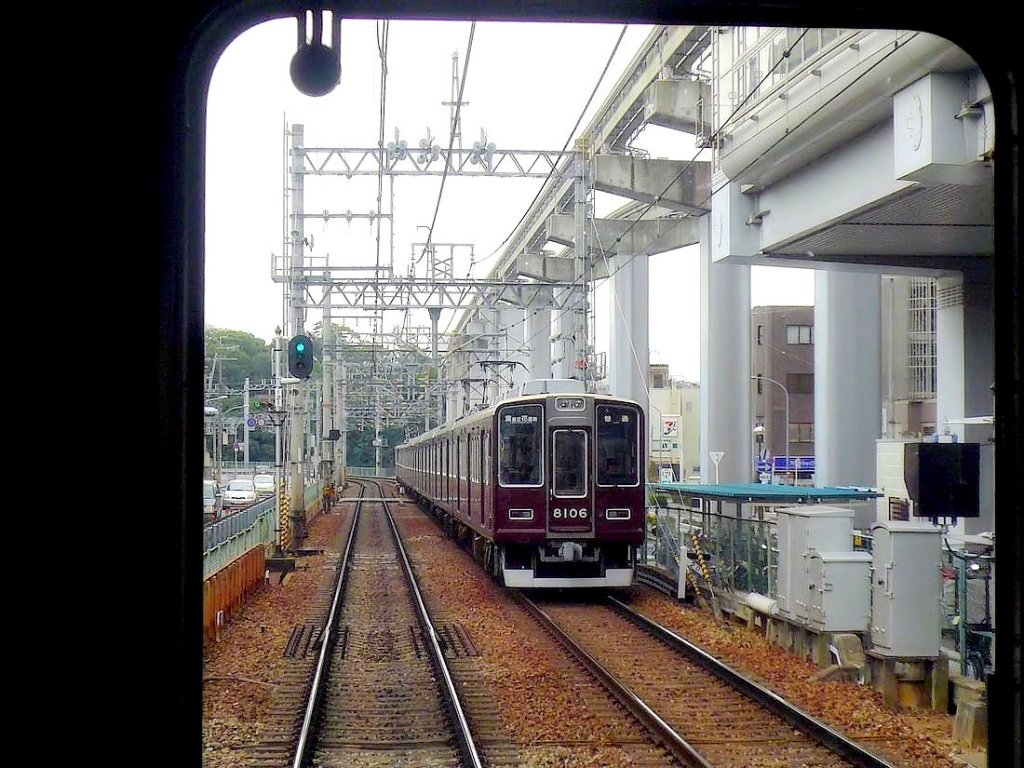 Der Hankyû-Konzern - Die Züge der 1990er Jahre: Serie 8000. Endlich ein etwas moderneres Design. 98 Wagen, 1988-1997 gebaut; einige Wagen mit Quersitzen. 2- und 8-Wagenzüge. Hier ist Zug 8006 (Endwagen 8106) unter den imposanten Anlagen des Osaka-Monorail in Osaka-Hotarugaike, 28.September 2009. 