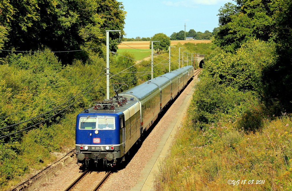 Der IC 134 ist der einzige InterCity der Verbindung Norddeich-Luxemburg der im normalem Betrieb ber die Gterumgehungsstrecke Oetrange-Luxemburg/Sd nach Luxemburg kommt.
Weil der IC 134 der Gegenzug des IC131 ist, der am frhen Morgen via Alzingen-Syren Luxemburg verlsst, muss er diesen Weg nehmen um die Wagenreihung nicht zu verndern.

Hier sehen wir ihn am 18.August 2011 kurz hinter dem Syrener Tunnel.