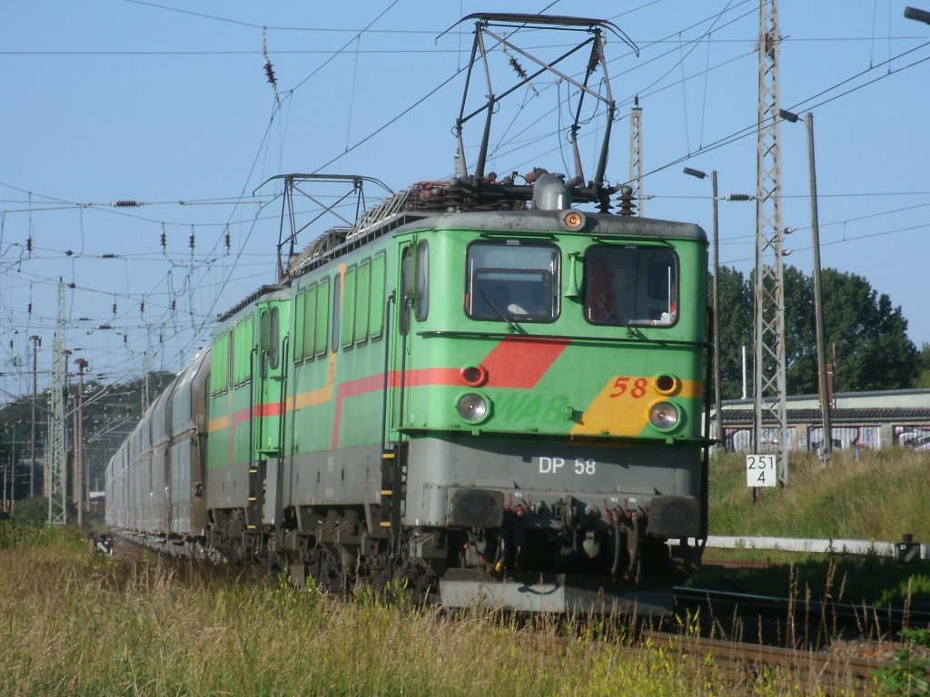 Der Kreidezug von Klementelvitz nach Peitz Ost,gezogen von DP 58 und 60, legte sich nach der Ausfahrt aus Bergen/Rgen,am 27.Juni 2011,in die Kurve.