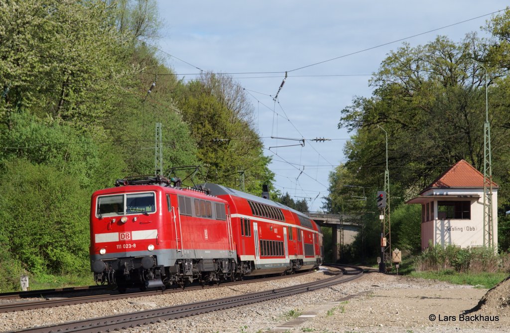 Der letzte M�nchner 11er fr�hling ist da. 111 023-8 hat am 04.05.13 einen RE nach Salzburg am Haken und durchf�hrt hier gerade A�ling. Noch bis ende dieses Jahres kann man auf dieser Strecke die M�nchner 11er zu Gesicht bekommen.