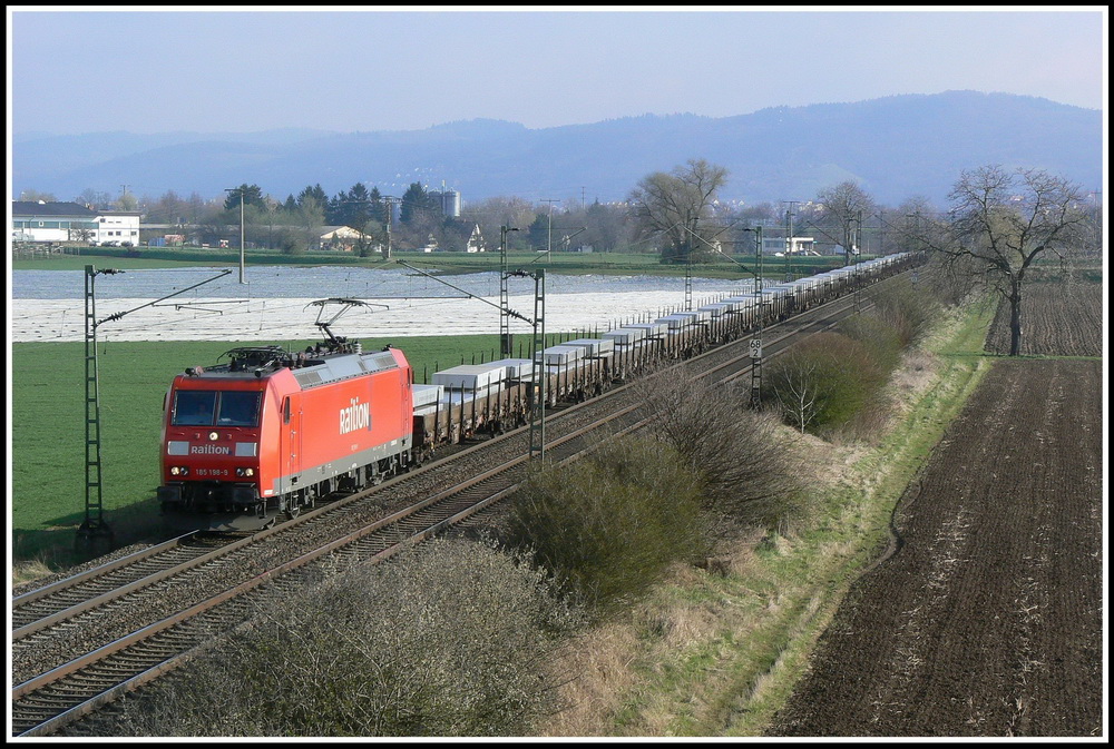 Der Mrz 2008 war regnerisch und grau; am 28.03.2008 schaffte es die Sonne aber trotzdem durch die Wolkendecke, als 185 198 bei Grosachsen auf dem Weg nach Sden ist.