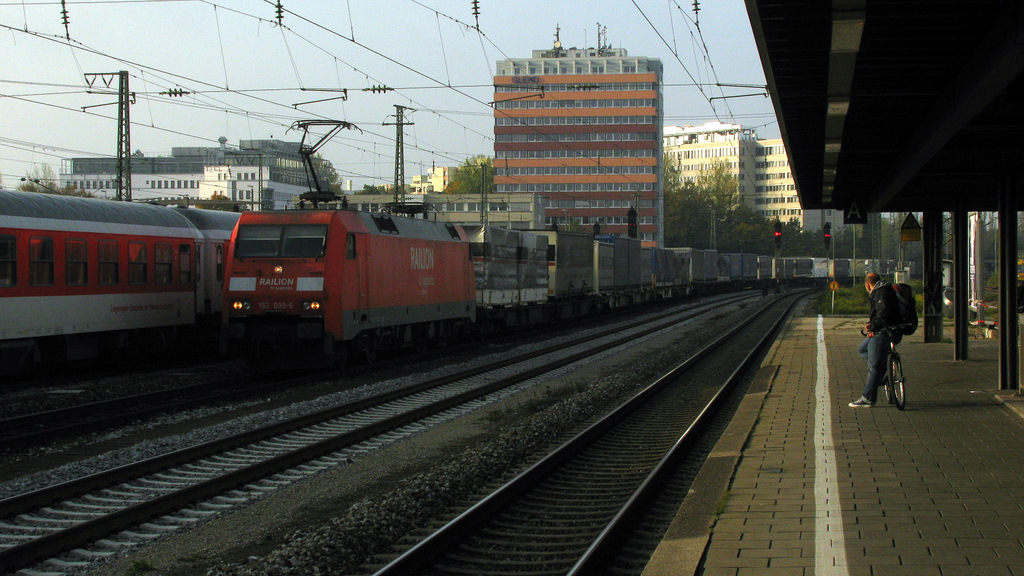 Der Mann mit dem Fahrrad wartet am 19.10. ebenso wie ich immer noch auf den RE Richtung Salzburg, w�hrenddessen kommt 152 035-6 mit einem Aufliegerzug vorbei.