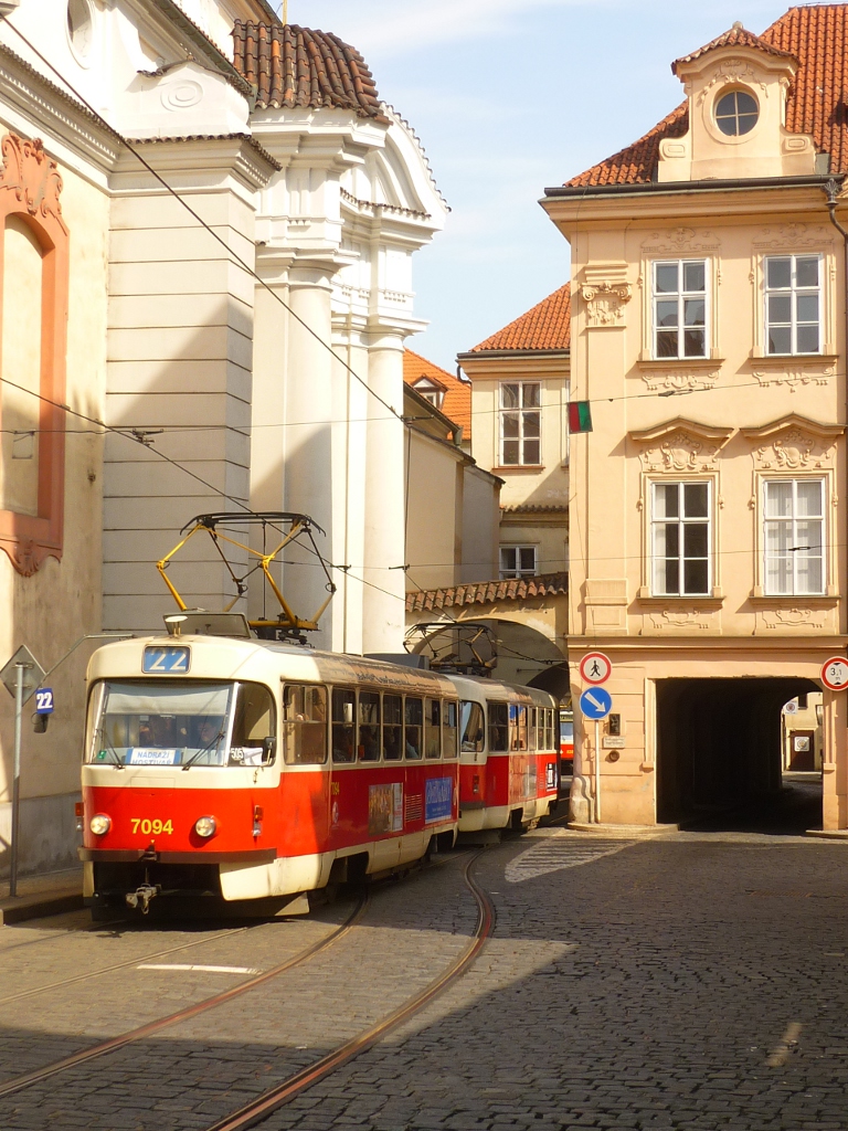 Der meiner Meinung nach schnste Ort in Prag ist der Kleinseiter Platz (Malostransk nměst), nicht zuletzt auch wegen der Hausdurchfahrt. Hier hat Wagen 7094 gerade die Engstelle passiert. Prag, 2012-04-04.