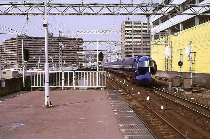 Der Nankai-Konzern: Zug mit Endwagen 50705 kommt von Osaka her unterwegs zum Internationalen Flughafen Kansai; der Gegenzug spiegelt sich gespenstisch in der runden Form seiner Seitenwand. Sakai, 16.August 2008. 
