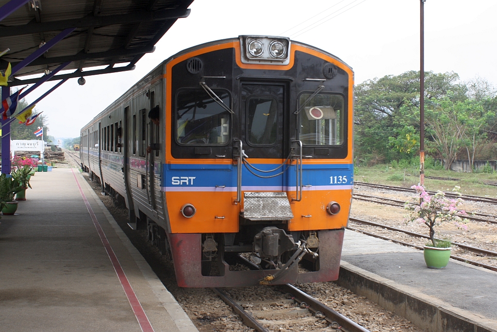 Der nur an Sa., So. und Feiertagen verkehrende Excursions Train 909 von Bangkok nach Nam Tok Sai Yok Noi mit dem THN 1135 (1A' 2', dh, Nippon Sharyo, Bj.1983) als letztes Fahrzeug am 11.M�rz 2012 im Bf. Kanchanaburi.