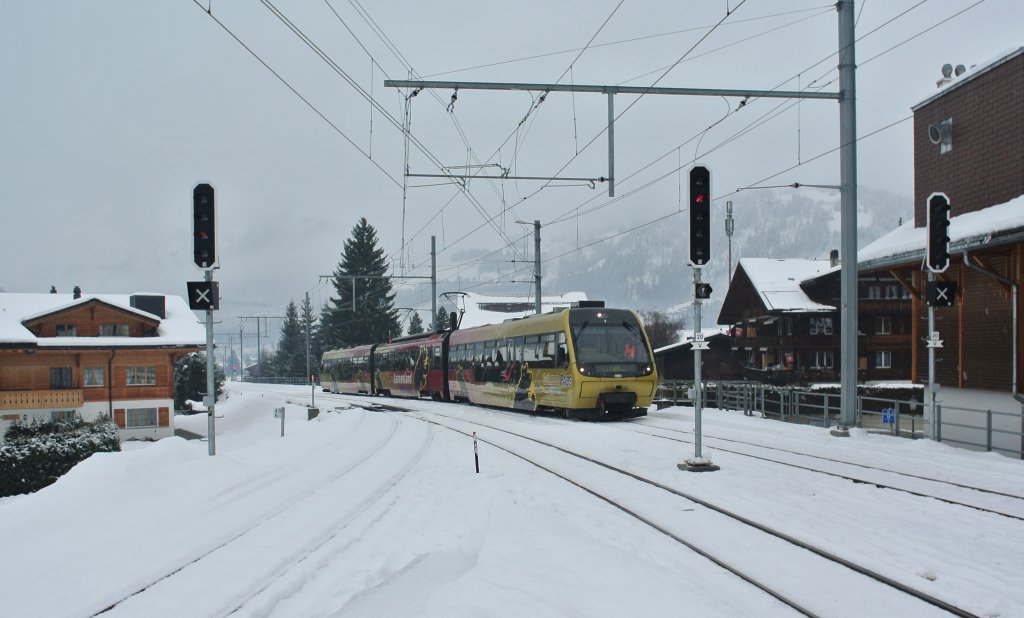 Der Pendelzug mit dem Be 4/4 5002 als Regio 2418 bei Einfahrt in Gstaad, 17.12.2012.