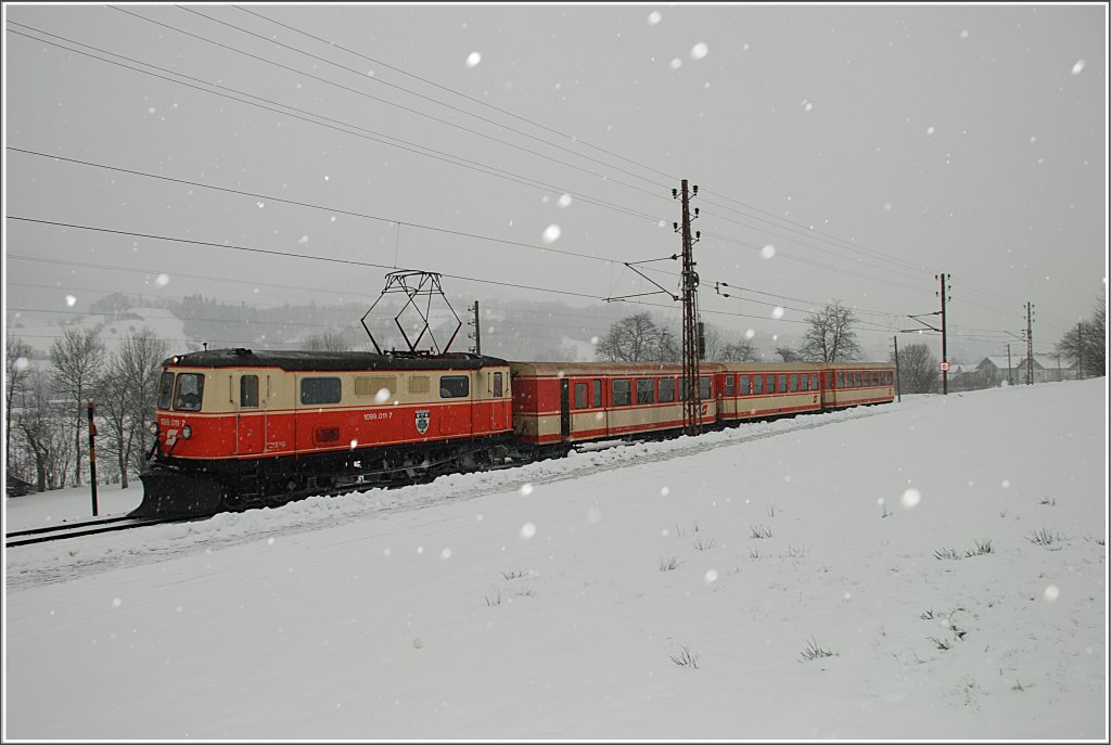 Der R 6811, der nur an Wochenenden bis nach Mariazell verkehrt, bestand am 7. Februar 2010 aus der Zuglok 1099 011  Puchenstuben  und drei blutorangen Waggons. Ich fotografierte sie zwischen Kirchberg an der Pielach und Schwerbach.