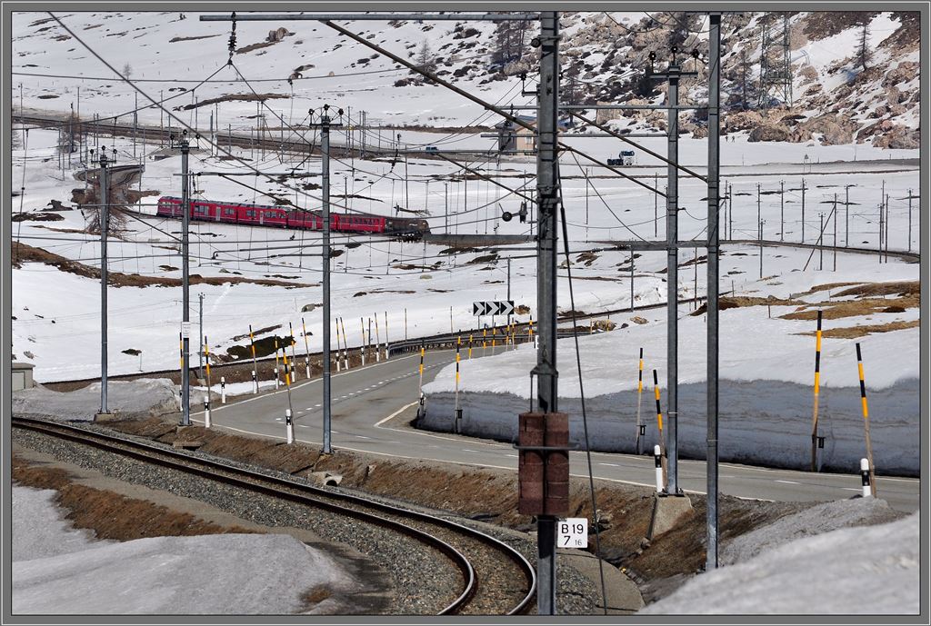 Der R1640 bei Lagalb verschwindet beinahe hinter dem Masten-, Stangen- und Leitungswald. (18.04.2013)
