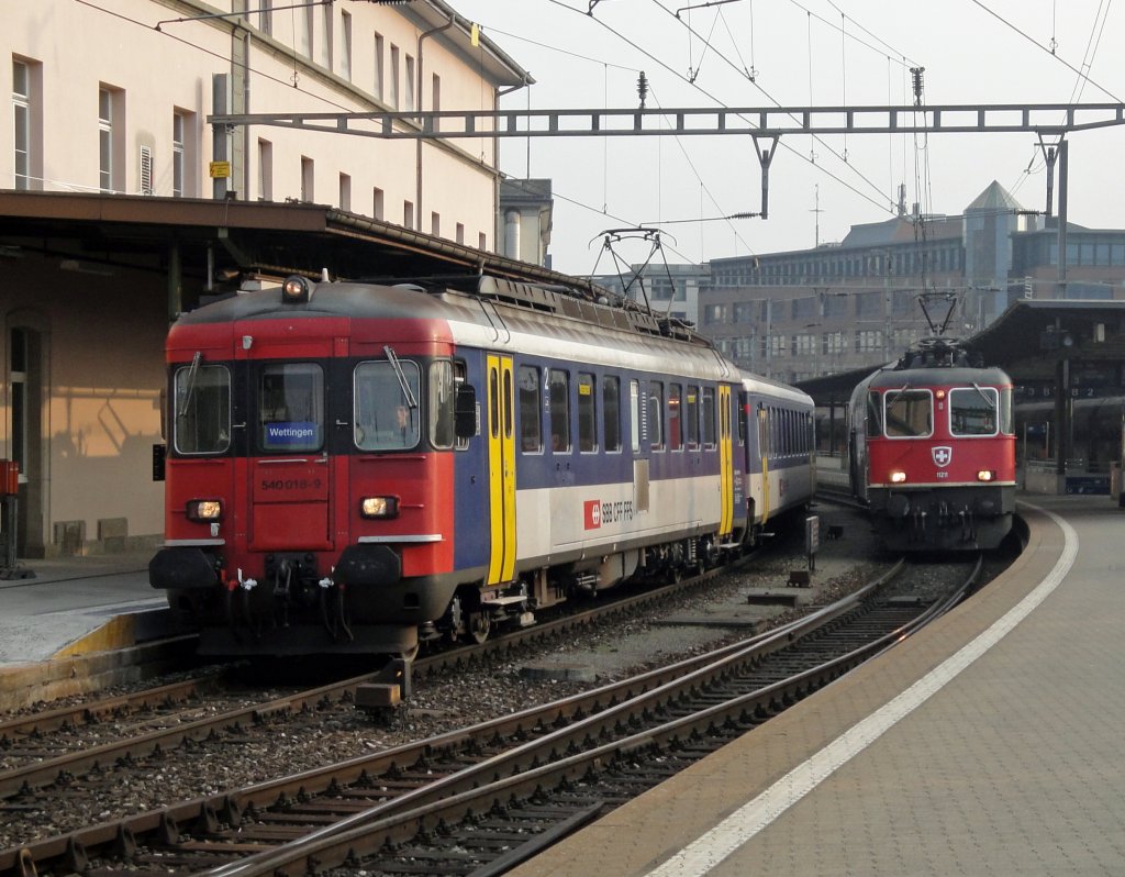 Der RBe 540 018-9 verlsst am 09.04.10 mit einem RE nach Wettingen den Bahnhof Olten. Rechst steht die Re 4/4  11211 mit einem Dosto-Steuerwagen.