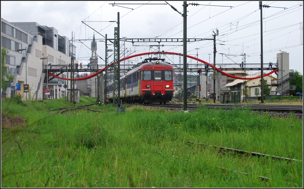 Der RBe legt los nach Biel und taucht gleich in die Schweiz ein. (Konstanz, 2. Mai 2010) Fotostandort ist hinter dem trennenden Erdwall. Die Wiese im Vordergrund ist Gleisbereich und wird regelmig benutzt, um Seehasen abzustellen, die lieben eben Grnes.
