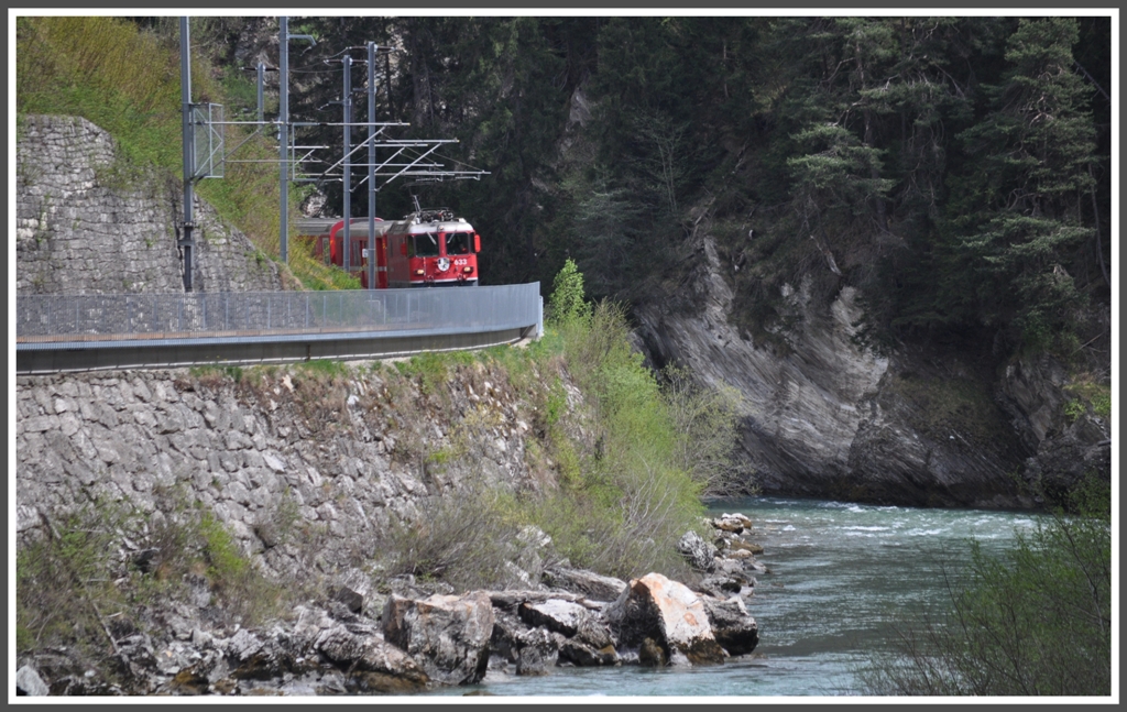 Der RE 1236 mit der Ge 4/4 II 633  Zuoz  schlngelt sich dem Voderrhein entlang Richtung Trin. (14.04.2011)