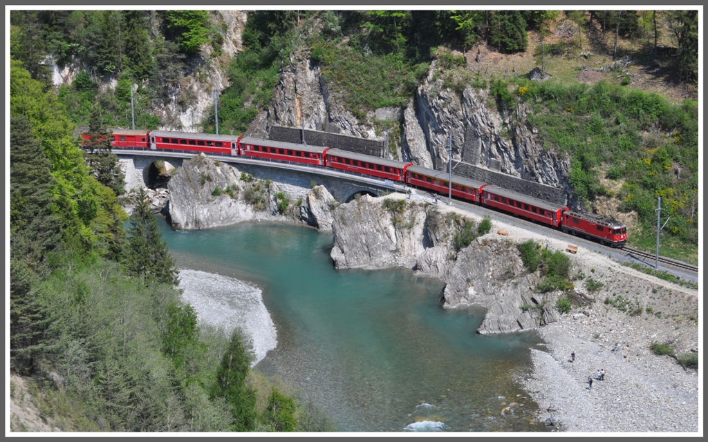 Der RE1245 mit der Ge 4/4 II 613  Domat/Ems  schlngelt sich unterhalb der Ruine Wackenau dem Vorderrhein entlang. (25.04.2011)