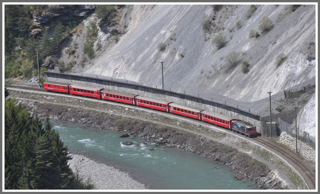 Der RE1249 mit der Ge 4/4 II 619  Samedan  duckt sich hinter die Steinschlagmauer oberhalb von Trin. (25.04.2011)