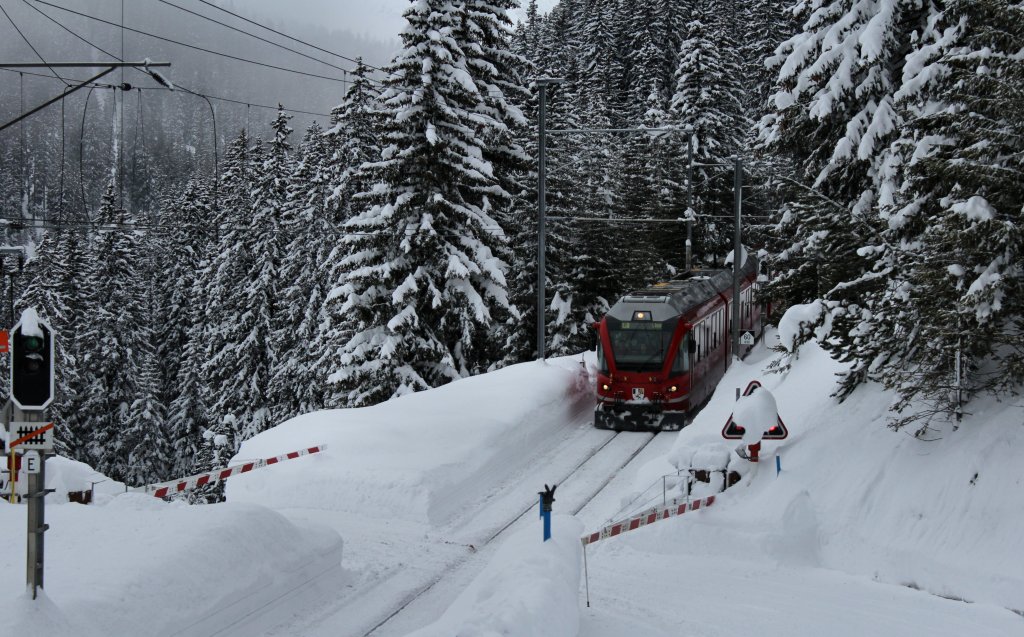 Der Regio nach Chur hat gerade Arosa verlassen und fhrt durch den tief verschneiten Wald dem nchsten Halt Litzrti entgegen.