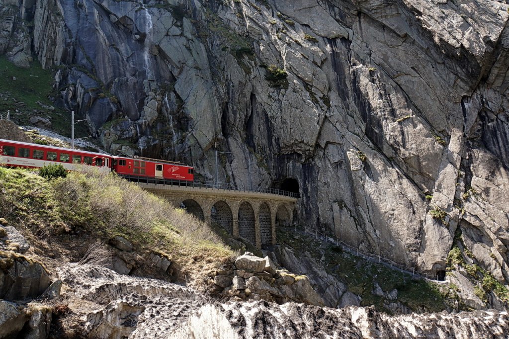 Der Regio nach Gschenen bei der Teufelsbrcke in der Schllenenschlucht. Fast sieht es so aus, als ob der Zug nicht in das enge Tunnelloch passt, aber es geht natrlich gut. 25.5.2012   