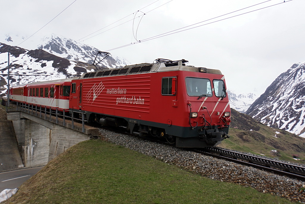 Der Regionalzug aus Sedrun berquert die Autostrasse oberhalb von Andermatt am 8.5.2012.