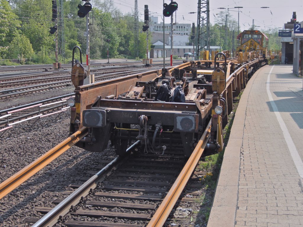 Der Rutschenwagen an einem Langschienenentladezug am 22.04.2011 in Aachen West. Whrend der Zug langsam vorwrts fhrt, fhrt der  Tintenfisch  mit zwei 120m langen Schienen an den Greifern genauso schnell ans Zugende und schiebt die Schienen ber den Rutschenwagen vom Zug.