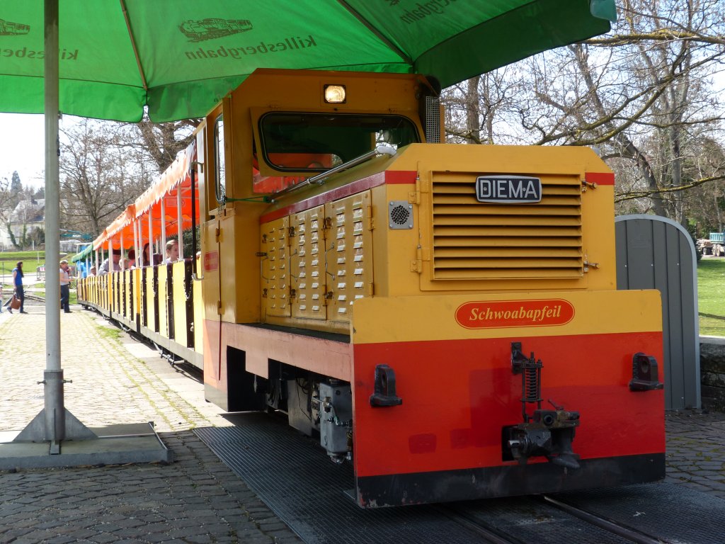 Der  Schwoabapfeil  der Parkeisenbahn in Stuttgart-Killesberg wird am einzigen  Bahnhof  der Rundstrecke von einem Sonnenschirm vor berhitzung geschtzt. 15.4.2013, Stuttgart Killesberg