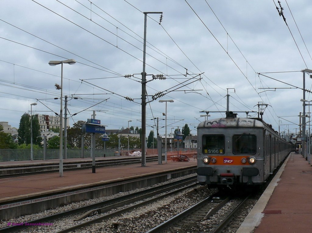 Der SNCF-Z6166 ist einer der betagten Inox-Triebzge aus der Reihe Z6100 fr 25kV Wechselspannung im Pariser Vorortverkehr.

Saint-Denis 06.05.09