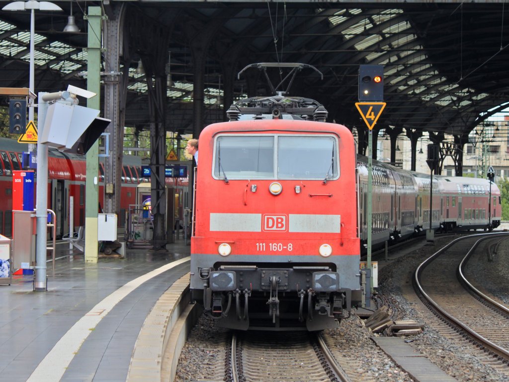 Der Tf der 111 160-9 lehnt sich am 08.09.2011 im Aachener Hbf weit aus dem Fenster der Lok. In den Monitoren auf dem Bahnsteig kann er die Tren an seinem Zug beobachten bevor er mit dem RE4 losfhrt.