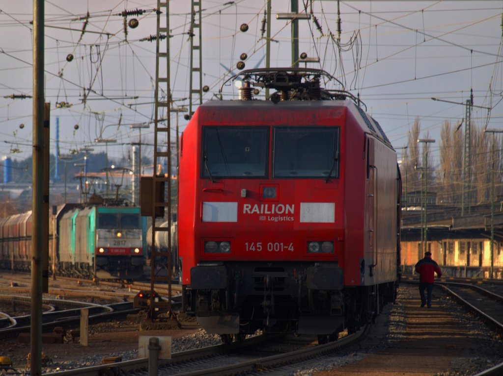 Der Tf hat 145 001-4 vor einen Kesselzug rangiert und an die Lok gekoppelt. Er ist nun auf dem Weg zum B�ro wo die Lokf�hrer den Papierkram erledigen und ihren Pausenraum haben. Links neben der 145er steht eine Cobra-Doppeltraktion vor einem langen G�terzug, f�r die geht es gleich �ber die Montzenroute nach Belgien geht. 21.11.2010
