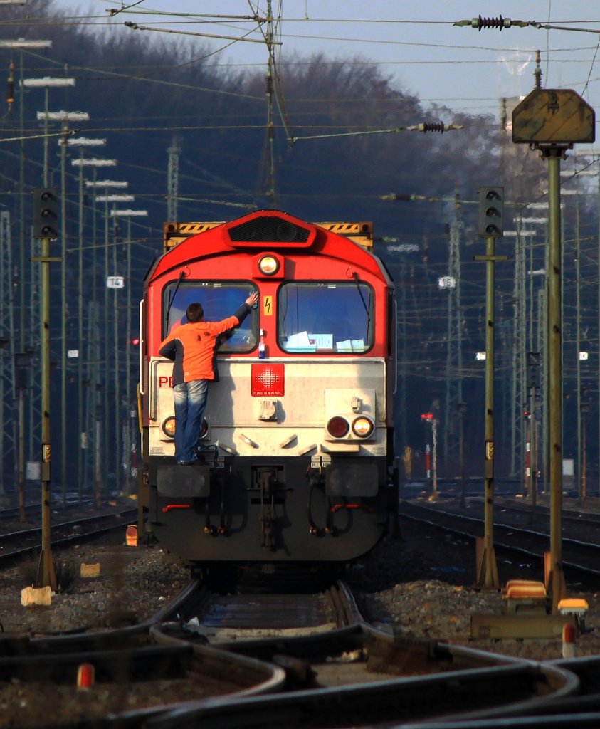 Der Tf der PB12 von Crossrail sorgt am 18.01.2012 in Aachen West an seiner Class66 fr freie Sicht bevor er mit der Lok einen Containerzug Richtung Kln zieht.