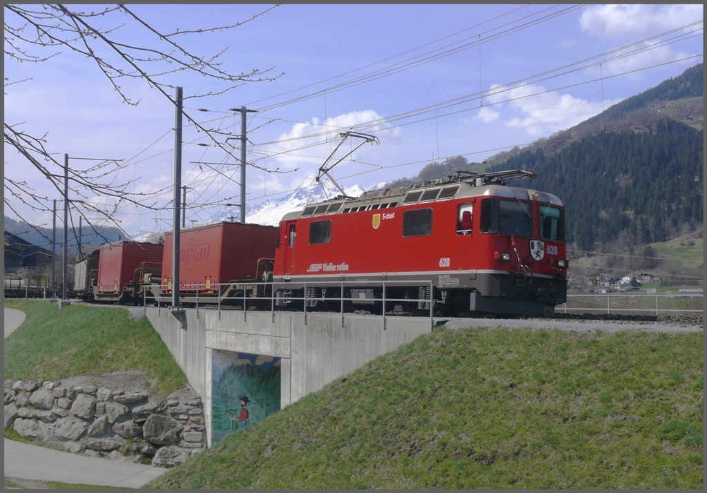 Der Valserwasserzug aus Ilanz mit Ge 4/4 II 628  S-chanf  erreicht Castrisch. Im Hintergrund der Cavistrau 3220m. (08.04.2010)