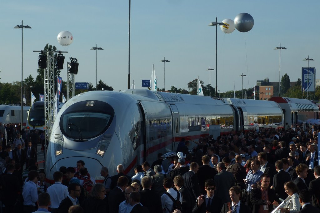 Der Velaro D auf der Innotrans 2010 kurz nach der offiziellen Weltpremiere am 22.9.2010. ber die Frontansicht gibt es ja schon untersch. Meinungen. Hier gut zu sehen sind auch die Dachaufbauten, die im Vgl. zur BR 406 optimiert wurden. Die Tren erinnern mich pers. ja an den  Metropolitian . Ach und mit der Baureihe wird auch die  Lounge  entfallen, bei der man immer direkt hinter eine Glaswandf auf die Strecke sehen konnte.
Im Bildhintergrund zu sehen: ICE S, ein Regionalzug aus Kroatien und hinter dem Velaro D ein instandgesetzter CFL-Wagen, der nach einem Brand wieder dem Besitzer zugefhrt wurde.
Berlin, der 22.9.2010