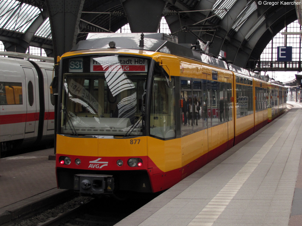 Der Wagen 877 ist einer von insgesamt 4 Fahrzeugen der AVG, die an der Front das AVG-Logo und einen neuen Look tragen. Am 14.03.2011 verlsst Wagen 877 mit einem weiteren Triebwagen den Karlsruher Hbf als S31 Eilzug nach Freudenstadt Hbf. Aufgrund der rund 10 mintigen Versptung des ICE 276 (links im Bild) hielt der Zug auerplanmig auf Gleis 2.