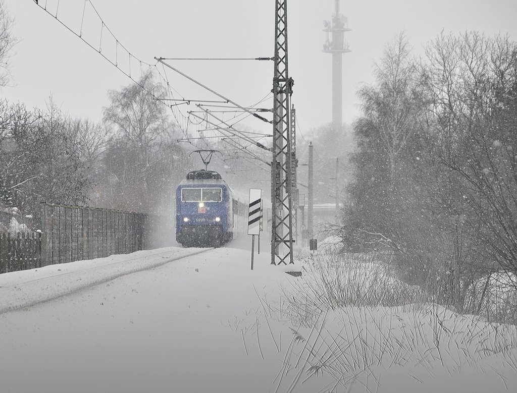 der ZDF-Express (120 151) kommt mit Flockenwirbel den Langendorfer Berg herunter, kurz vor dem Erreichen des Bf Stralsund am 16.02.2010