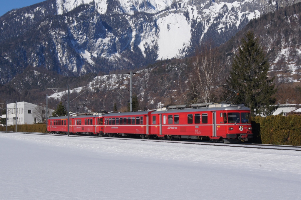 Der zusammengewrfelte S-Bahnzug mit dem Be 4/4 515 an der Spitze fhrt am 21.2.12 von Ems Werk Richtung Domat/Ems.