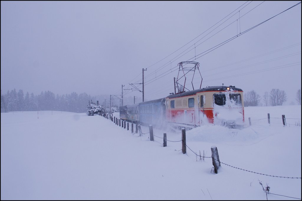 Die 1099 001 kmpft sich mit dem REX 6805 durch die dichten Schneemassen, die es in der Nacht auf den 08.01.2012 geschneit bzw. angeweht hat. Einfahrt Mariazell.