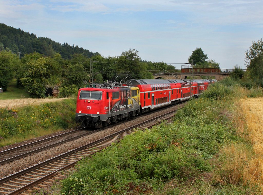 Die 111 024 mit dem BR Radlzug nach Piding am 04.08.2012 unterwegs bei Dettenhofen.
