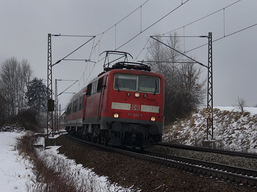 Die 111 028 am 16.01.2010 mit einem RE nach Salzburg unterwegs bei Ostermnchen. 