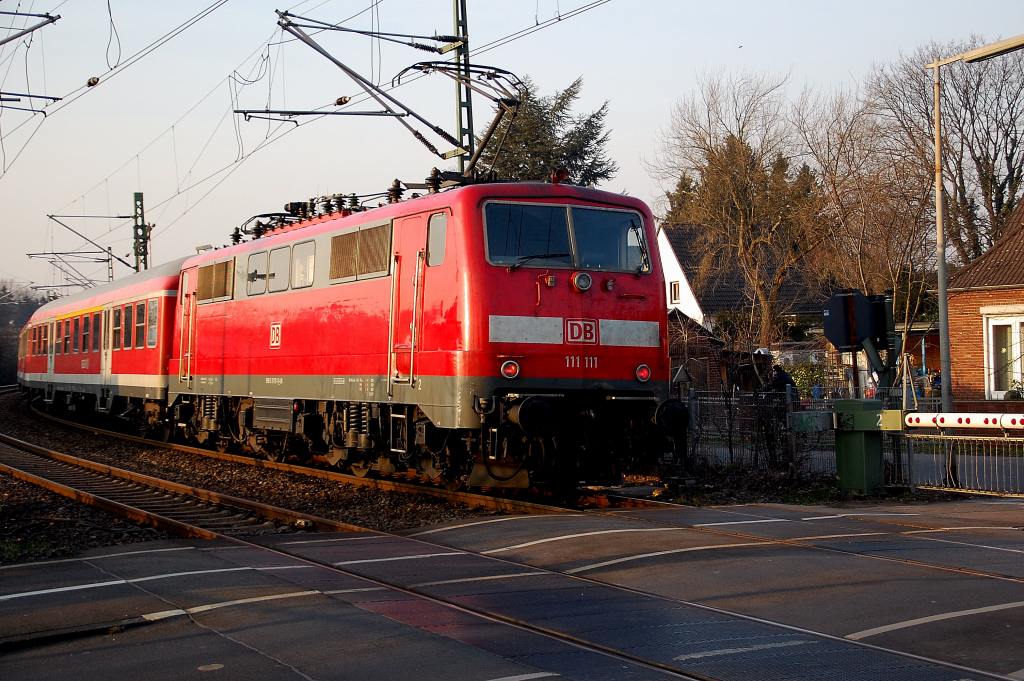 Die 111 111-1 schiebt eine Garnitur RE8 Zwischentakt nach Kaldenkirchen hier ber den Bahnbergang Bergheimer Strae in Grevenbroich. 4.3.2011