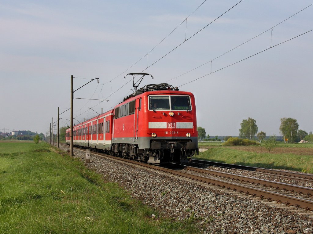 Die 111 227 mit einer S Bahn nach Bamberg am 24.04.2011 unterwegs bei Bubenreuth. 