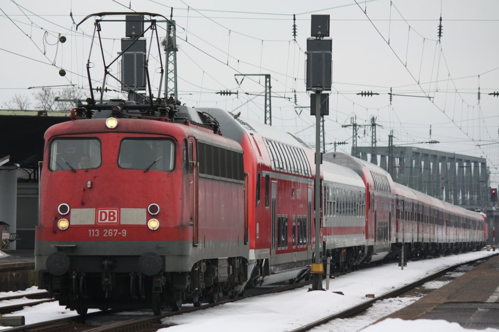 Die 113 267-9 zieht ihren Pbz 2476 bestehend aus einem DOSTO, IC, DOSTO, 9 mal n-Wagen und am Ende die 111 080-8 am 02.01.2011 durch Kln Messe Deutz.