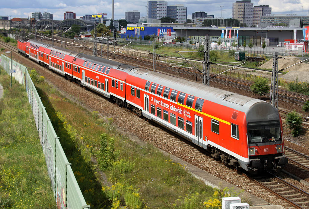Die 114 002-9 schiebt die RB10 von Nauen durch Berlin Warschauer Strae nach Berlin Schnefeld Flughafen am 11.08.2012