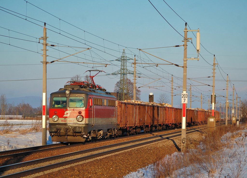 Die 1142 705 ist am 18.12.2010 mit einem Holzzug
der untergehenden Sonne bei Marchtrenk entgegengefahren.