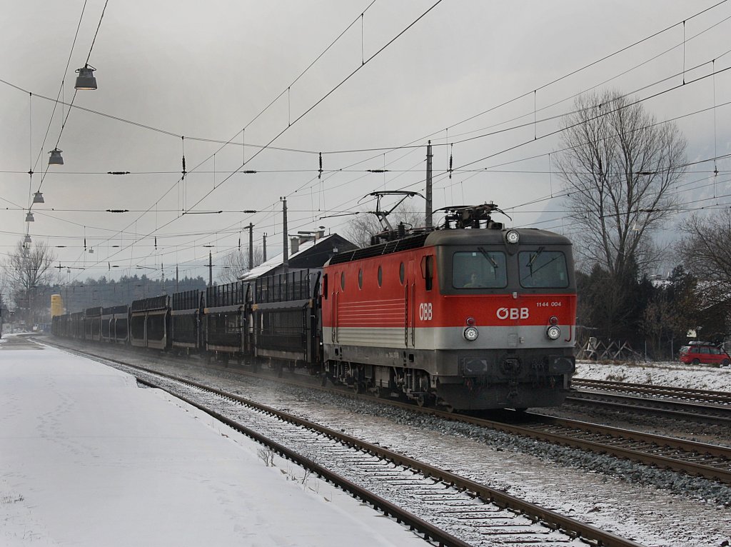 Die 1144 004 mit neuen LED,s am 19.12.2009 mit einem lehren Autozug bei der Durchfahrt in Brixlegg. 