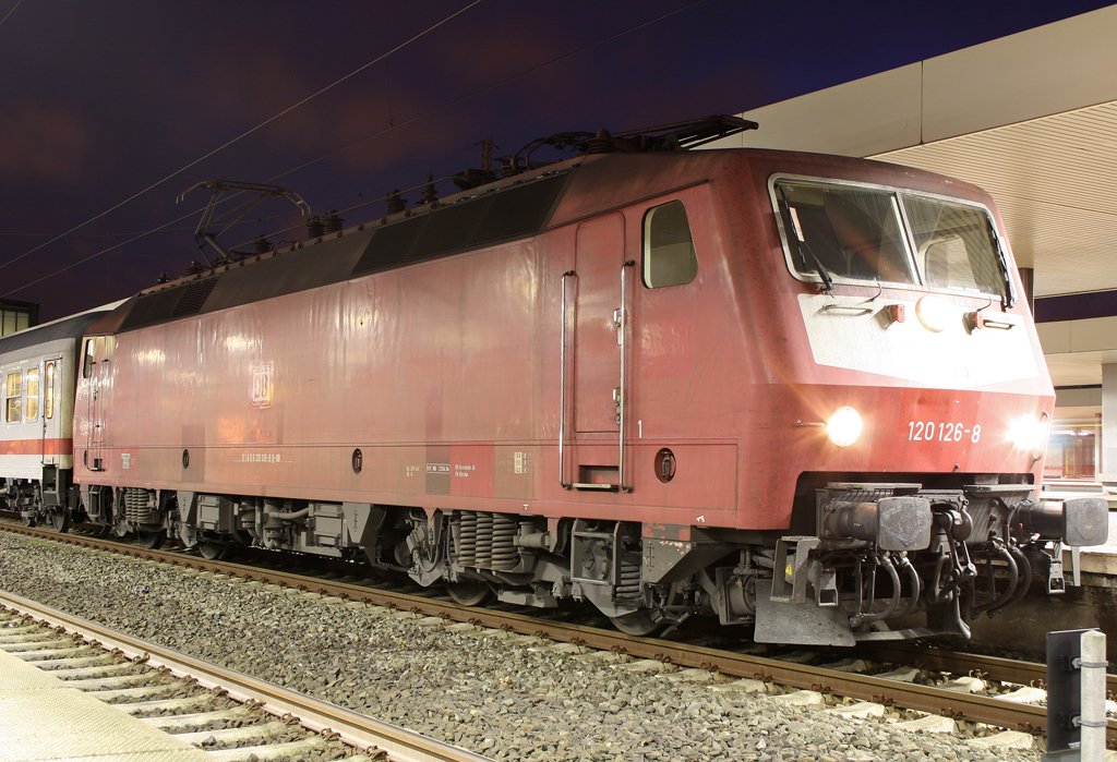 Die 120 126-8 in rustikalem Orientrot mit Latz zieht einen IC in Duisburg HBF am 29.11.2009
