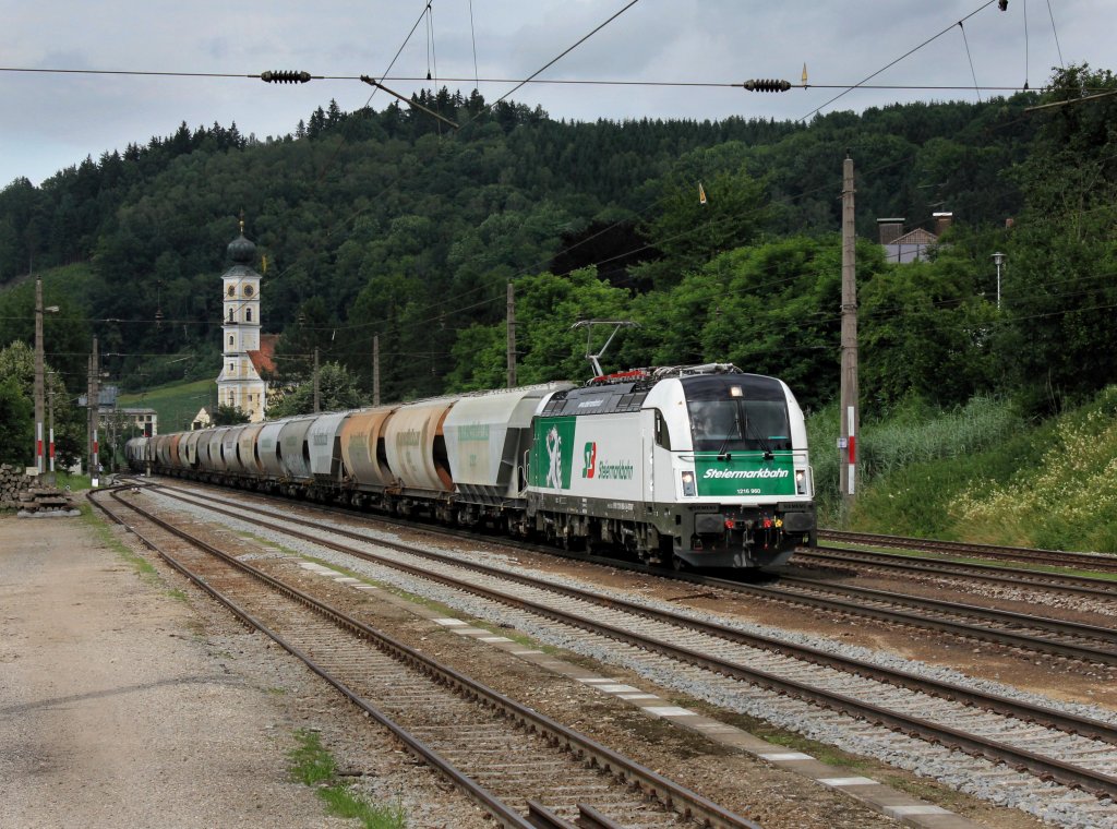 Die 1216 960 mit einem Getreidezug am 07.07.2012 bei der Durchfahrt in Wernstein.