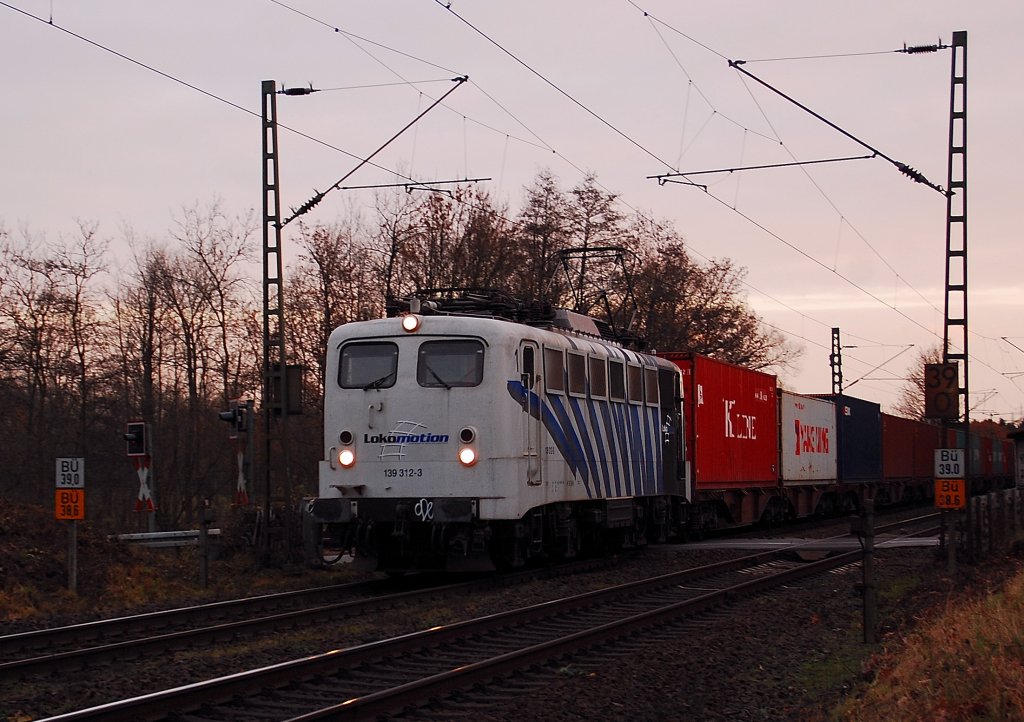 Die 139 312-3 von Lokomotion ist hier am Bahnbergang Tilmeshof Broicher Seite bei schon schwachem Abendlich zu sehen, als sie in Richtung Krefeld vorbei fhrt. 26.11.2011