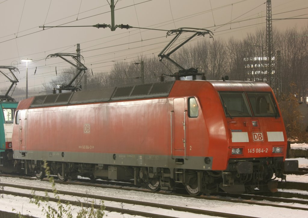 Die 145 064-2 mit SIEMENS Sticker auf der Front steht am Abend der 07.12.2010 in Aachen West.