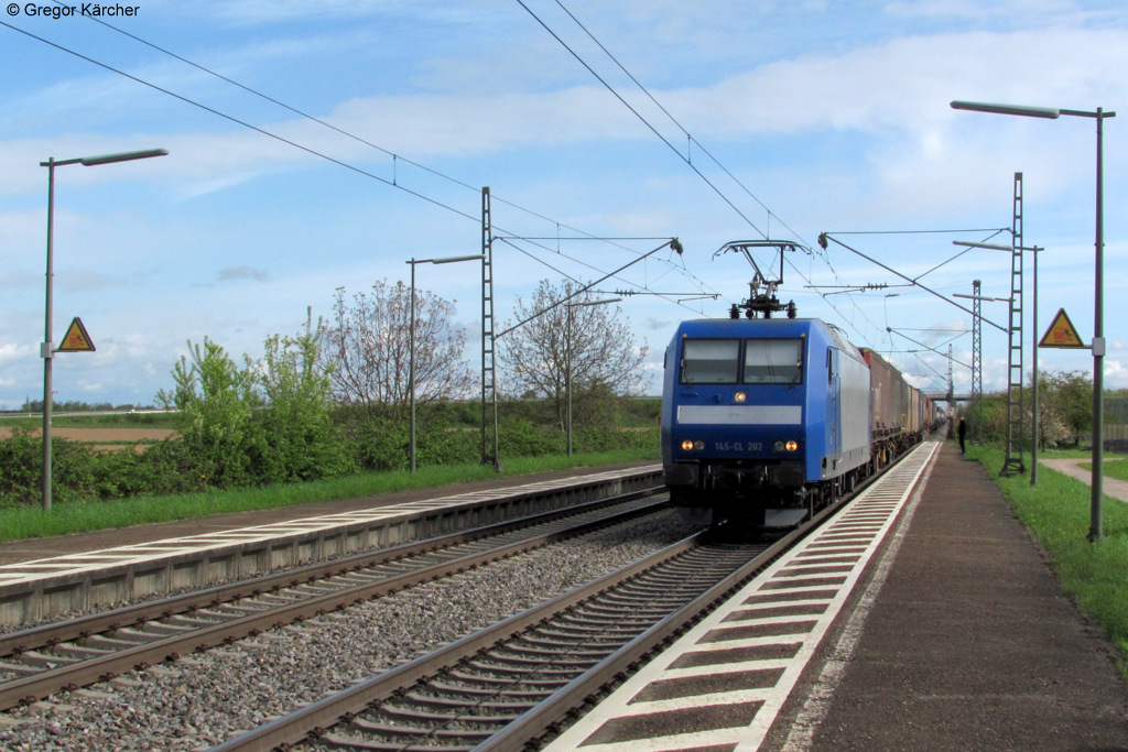 Die 145 CL 202 (145 098-0) kommt mit einem Containerzug auf dem Gegengleis durch Ringsheim gefahren, um Platz fr den ICE nach Basel zu machen. Dieser kam weniger als 20 Sekunden, nachdem der Gterzug hier durch war. Im Hintergrund fast am Bahnsteigende steht Hannes Mller. Aufgenommen am 21.04.2012.