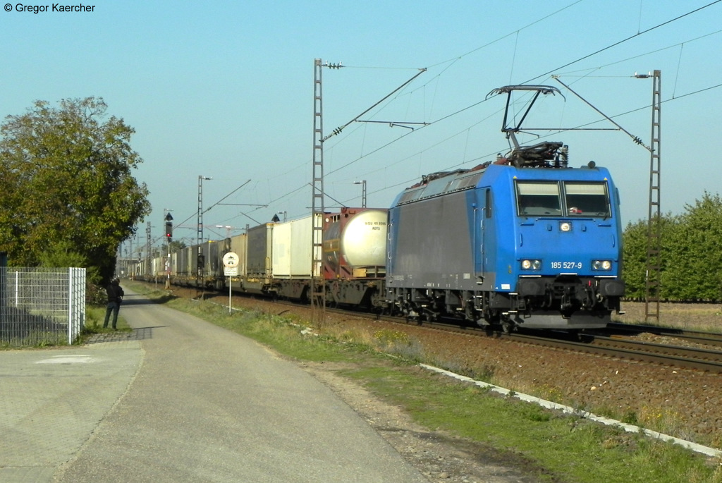Die 185 527-9 mit einem Containerzug am 22.10.2011 bei Wiesental. Vorne am Zaun links steht Hannes Mller.